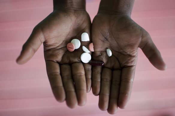 7-year-old Linda with the pills she has to take for her tuberculosis during her visit to the 6-mile health clinic to receive her treatment. 