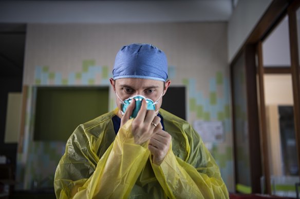 Nurse Jarrod Tunks checks the fit of his facemask as he prepares to test walk-up patients. Nurses are at the front line of the numerous testing areas now available in Sydney.