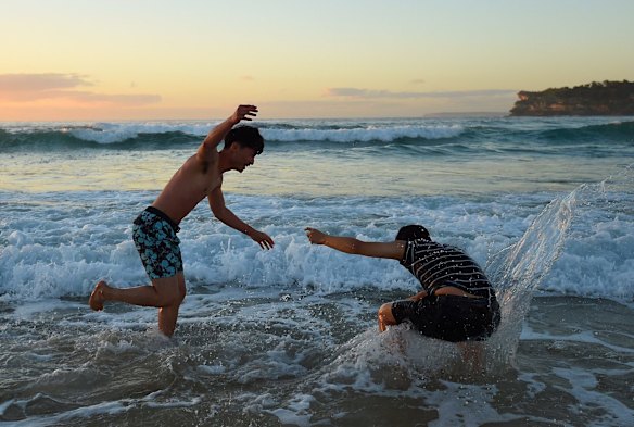 Two men visiting from Korea celebrate the new year as the sun rises over Bondi Beach, Sydney. 