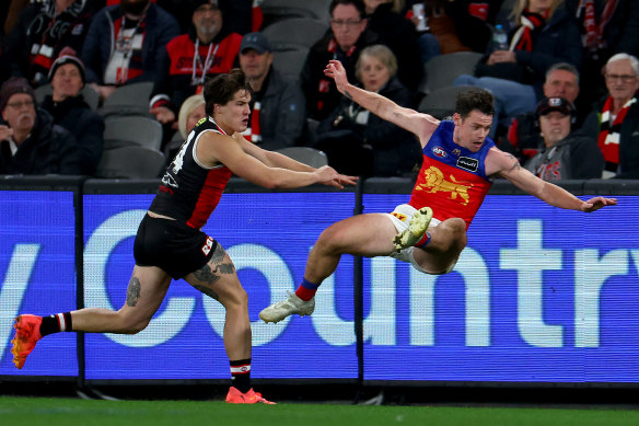 Out of my way: Lions great Lachie Neale is pushed by Liam Stocker at Marvel Stadium on Sunday.