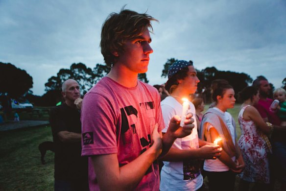 People hold candles during a candlelight vigil/service a t the Tyabb oval for 11yr old Luke Batty who was murdered at the hands of his father.