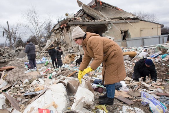 Neighbours and relatives help remove the rubble of a house destroyed with shelling in Markhalivka.