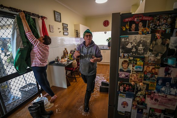Brian and Glenys Mulcahy prepare the kitchen in their Rochester home before it is inundated by flood waters. 