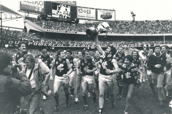 Peter Bosustow, premiership cup in hand and Carlton scarf flowing, leads the triumphant Blues on a victory lap of the MCG after the 1982 grand final.