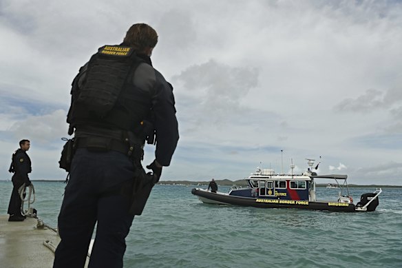 Australian Border Force (ABF) marine tactical officer Scott Emmett (right) on a fast response boat patrolling off Thursday Island.