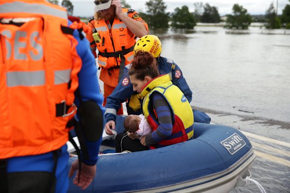 Sydney storms. A woman and her baby being brought across for medical attention in Maitland.
