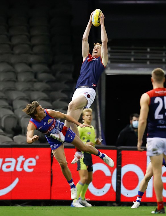 Harrison Petty flies high for the Demons as he takes a spectacular mark over Patrick Lipinski of the Bulldogs.