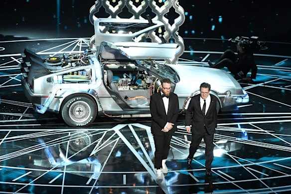 Seth Rogen and Michael J. Fox step out of the DeLorean.