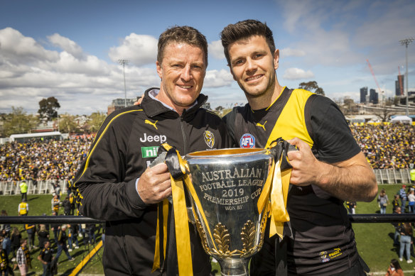 Memories live on: Damien Hardwick and Trent Cotchin take hold of the 2019 premiership cup. But the Tigers now face several painful years of a rebuild.