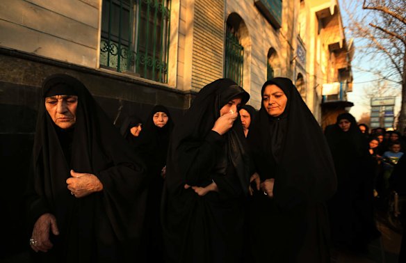 The sister of killed asylum seeker Reza Barati, Kowsar, 4th from left, is supported by her aunt, 2nd from right, after the memorial service.