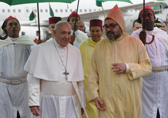 Pope Francis is greeted by Morocco's king. 