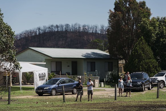  Lake Conjola residents watch as the Taipan Helicopter takes off for its aerial survey. 