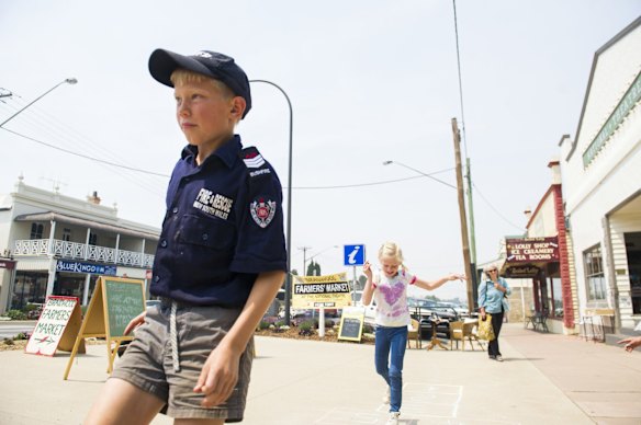 William and Ellie Honey playing hopscotch on the sidewalk as smoke haze continues around Braidwood.