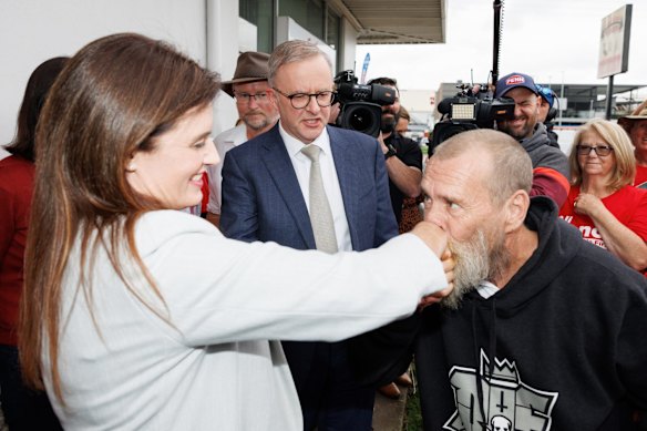 Labor candidate for Dickson Ali France and Opposition Leader Anthony Albanese are greeted by a supporter their visit to a pre poll booth in the seat of Dickson, in Queensland.