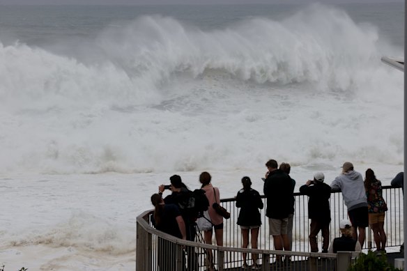 People watch the huge swell at Bondi Beach.