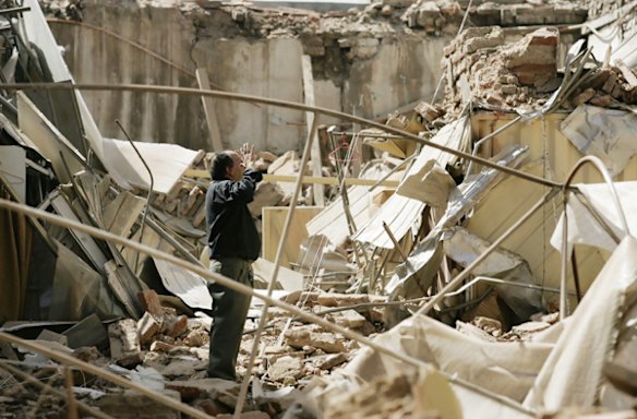 A man stands amidst the rubble of a building destroyed in an earthquake in Santiago.