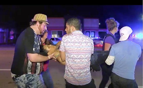 An injured person is escorted out of the Pulse nightclub.