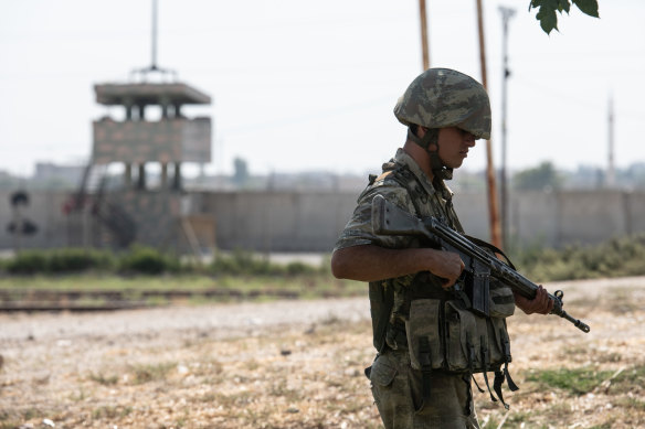 A Turkish soldier patrols on the Turkish side of the border between Turkey and Syria on Wednesday in Akcakale.