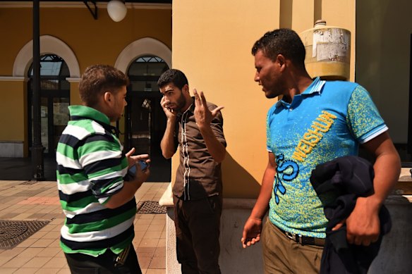 Men from Morocco who were some of the 415 people rescued on Wednesday off the Libyan coast by the Migrant Offshore Aid Station (MOAS) supported by Medecins Sans Frontieres (MSF) on the MY Phoenix wait for their train in Taranto, Italy.