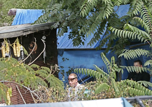 Authorities walk next to shacks in the backyards of a home in Antioch, California, where authorities say kidnapped victim Jaycee Lee Dugard lived.
