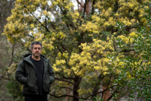 Dylan Martorell by the Yarra River with one of the wattles he has transcribed into music.