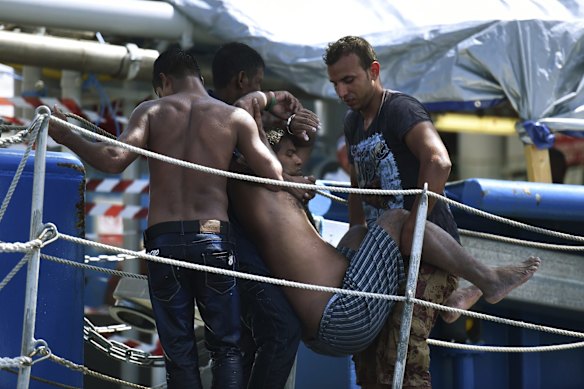 A refugee is carried up the gangway of a Swedish Coast Guard ship as they rescue a total of 441 people.