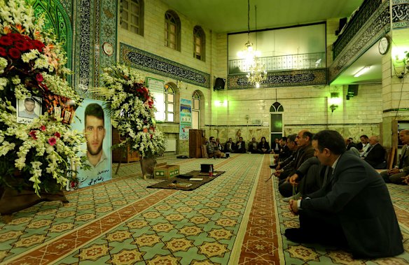 Men gather for prayers during the memorial service of killed asylum seeker Reza Barati.