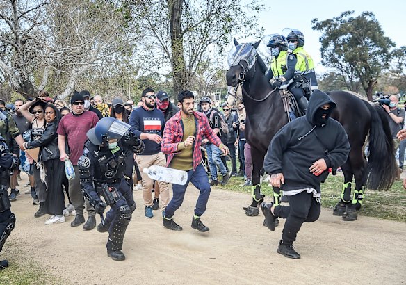 Protestors break through a police line at Albert Park.
