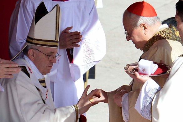 Italian cardinal Angelo Sodano (right) puts the Fisherman's Ring on a finger of Pope Francis during his inauguration mass.