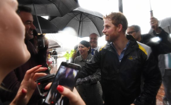 Prince Harry meets crowds at Campbell Cove, Circular Quay in very wet weather on June 7, 2017 in Sydney, Australia.