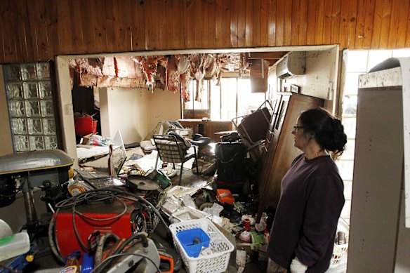 Patricia Whitehead surveying the damage to her Hooke Street home, Dungog, where flood waters reached the ceiling.