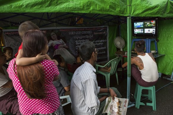 People gather on a street to watch vote counting on the local news in Yangon, Myanmar.