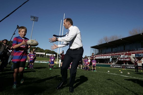 Opposition Leader Tony Abbott has a throw with the Under-9 Manly Christian Brothers players during his visit to Brookvale Oval in NSW.