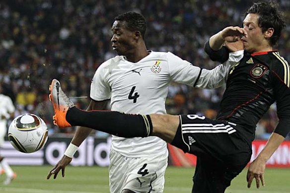 John Pantsil of Ghana, left, and Mesut Oezil of Germany vie for the ball.