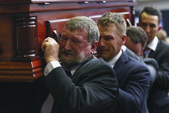 Gregory Hughes, left, father of Phillip Hughes, helps to carry Phillips's coffin during his funeral.