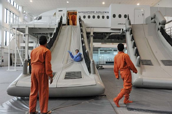 Singapore Airlines cabin crew perform a land evacuation exercise from a mock-up plane as part of their safety training.