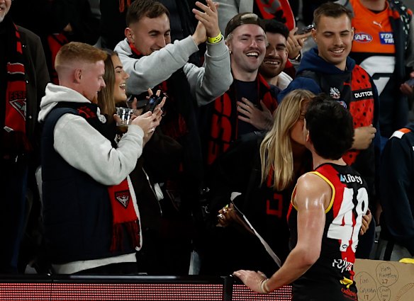 Liam McMahon of the Bombers is embraced by family and friends after the match against the GWS Giants.