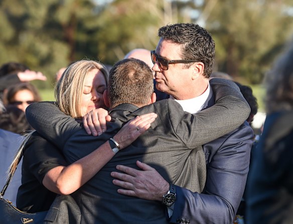 Nicky Brownless, Alastair Clarkson and Gary Lyon hug after the lap of honour.