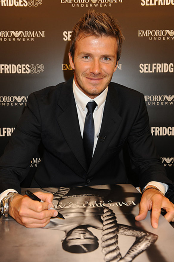 David Beckham signs a poster from the new campaign.