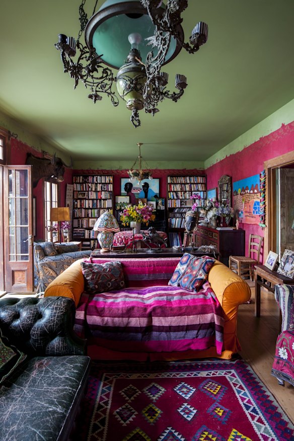A 100-year-old Turkish green-glass gaslight hangs over the sitting room, enhancing the room’s already vibrant colours. “The striped throw over the orange sofa is a present from my sister.”