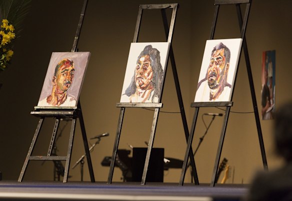 Myuran Sukumaran's paintings sit at the back of the stage during the funeral service.
