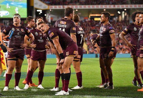 Maroons players watch the replay after a try by James Tedesco.