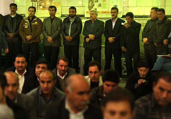 Male family members of killed asylum seeker Reza Barati stand at the rear of the mosque to recieve condolences during the memorial service.