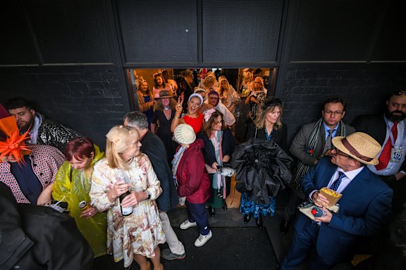 Race fans duck for cover on a very soggy day at Flemington Racecourse.