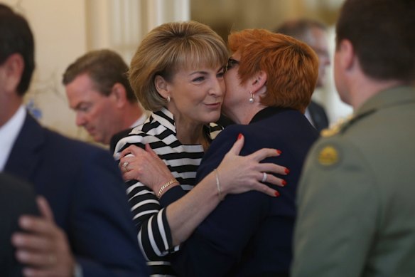 Senator Marise Payne is embraced by Senator Michaelia Cash before the ministry swearing in ceremony at Government House on Monday.