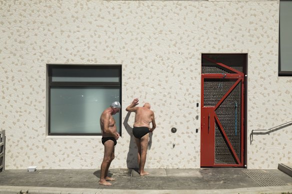 Members of the North Bondi Swim club washing the sand off their feet at Bondi Beach after a swim.