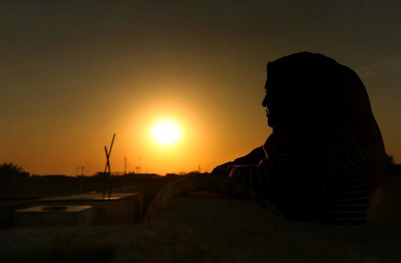 A female internally displaced person (IDP) from Fallujah watches the sun set over Baghdad, Iraq. This woman lived in Fallujah when the Islamic State, also known as ISIS, took over Fallujah.