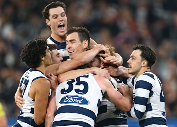 Geelong players mob Oliver Wiltshire after he kicked his first AFL goal.