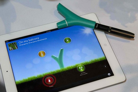 A Parrot Flower Power wireless device is displayed on top of an iPad. The device monitors conditions of your plants and sends a visual alert if a plant needs attention.