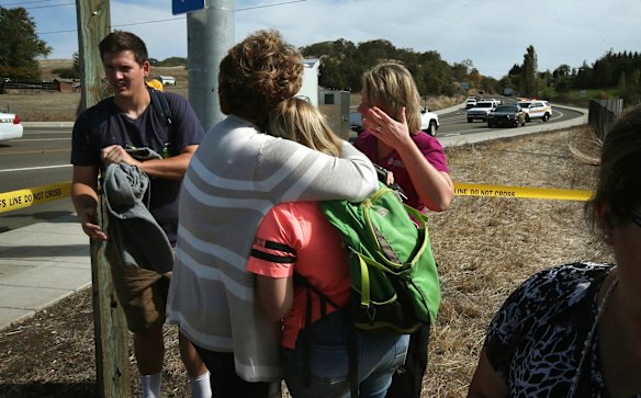 People console each other on a road leading to the Umpqua Community College campus in Roseburg, Oregon, following a deadly shooting at the school.  